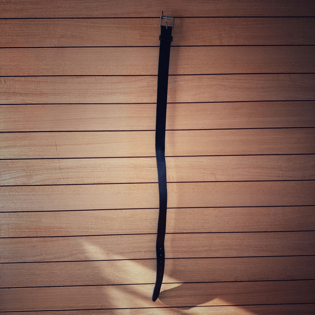 使用していくうちに体型に沿ってカーブしてきたREDWING黒レザーベルトの全体写真。