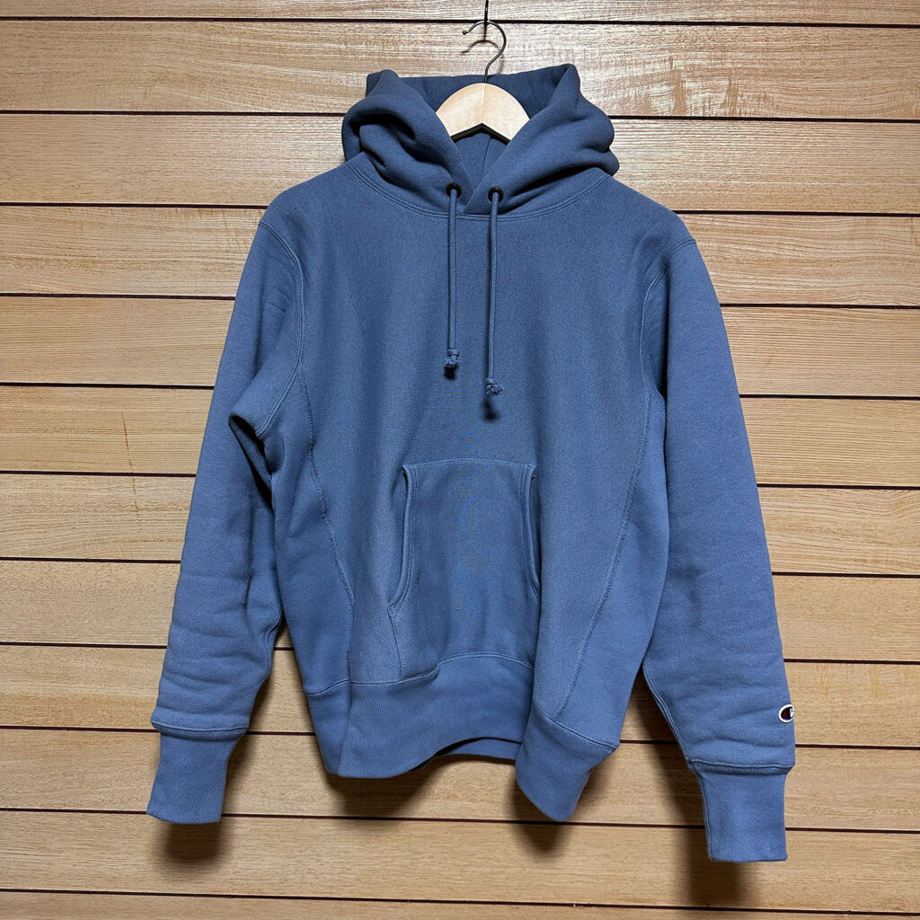ブルーグレーのチャンピオン リバースウィーブパーカーが掛けられている写真。