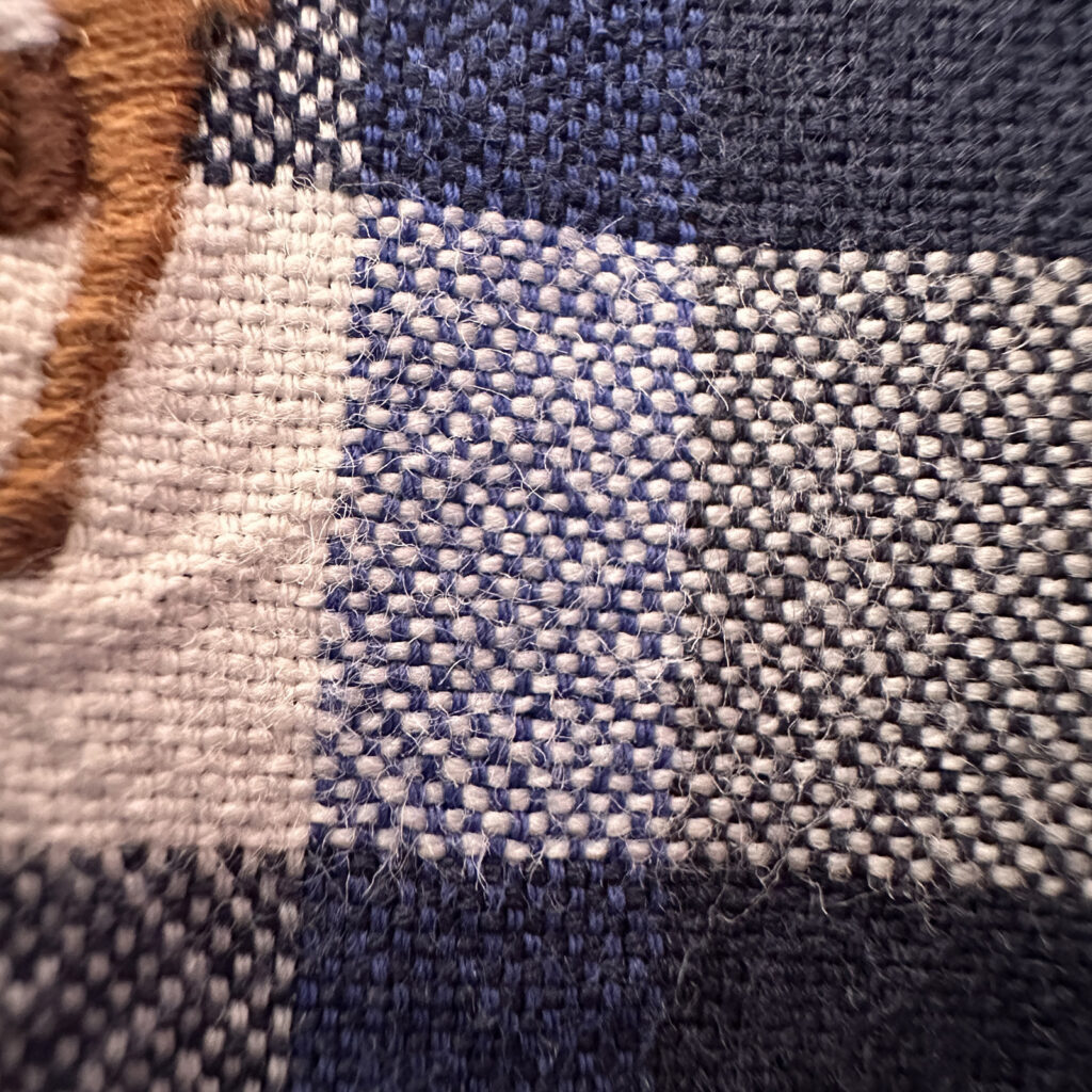 ボタンダウンシャツの襟元のクローズアップ。襟先のボタンと、ラルフローレンのブランドタグが見える、記事の核心部分を象徴するカット。