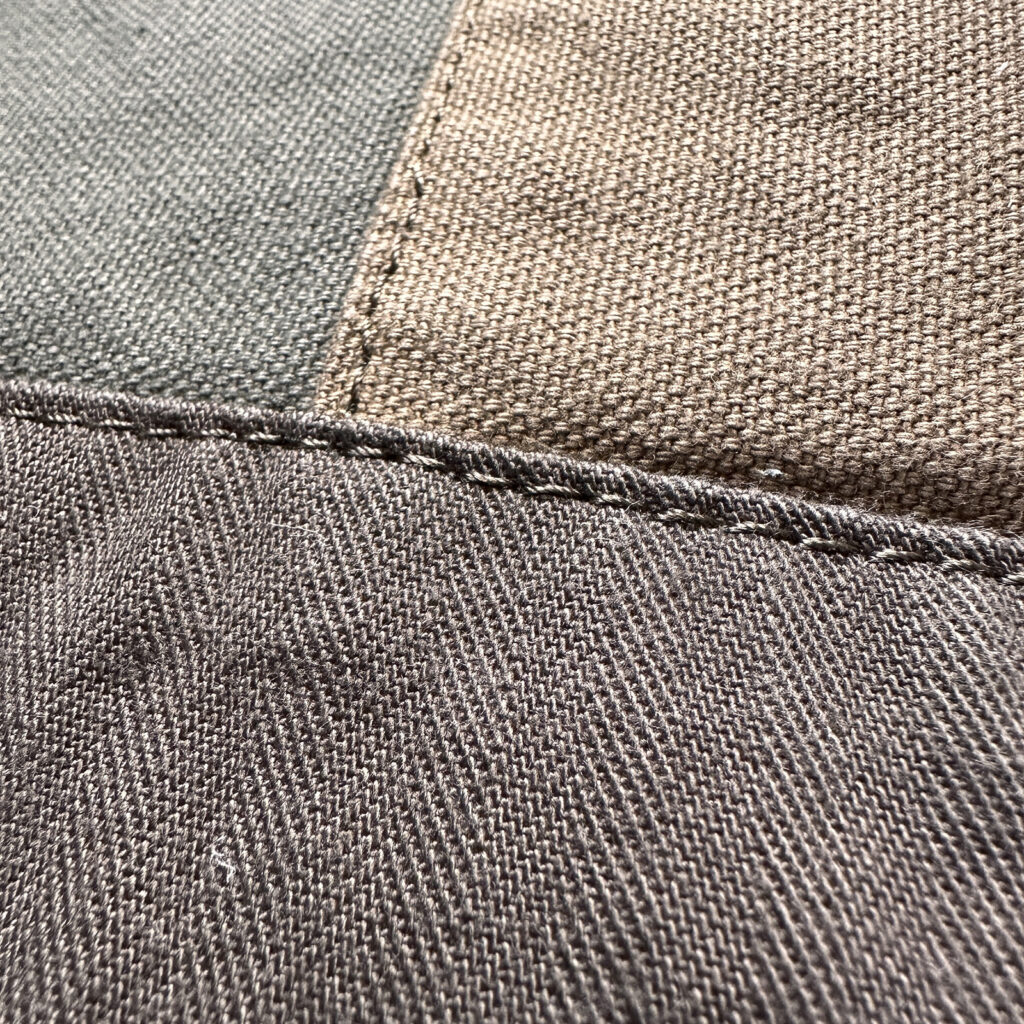 ラルフローレンのバックパックの生地アップ。平織りのキャンバス地とV字模様のヘリンボーン（杉綾織）が縫い合わされたパッチワークの詳細。